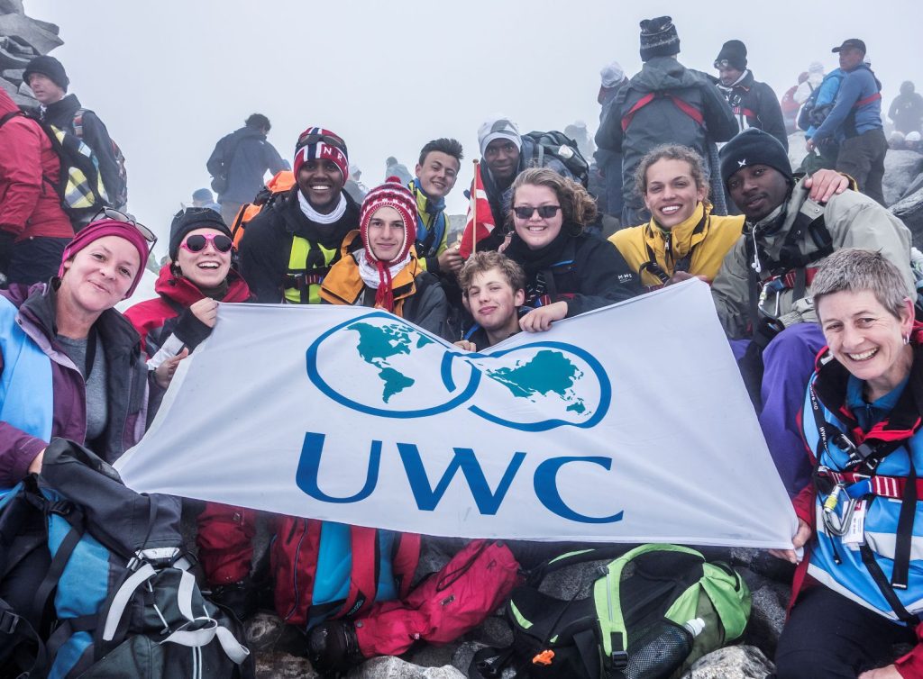 Students and teachers summiting mountain and raising UWC flag