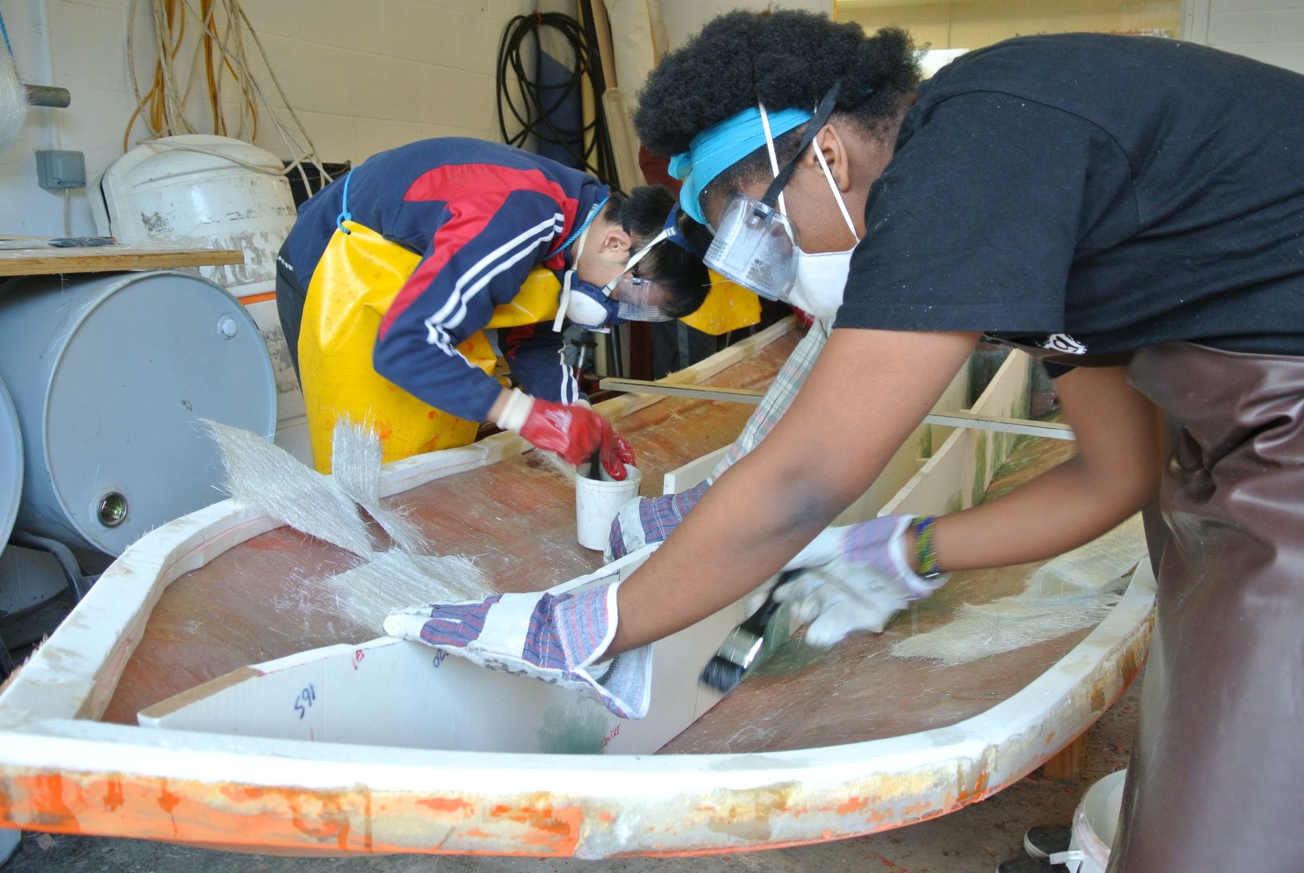 Students building a boat out of wood.