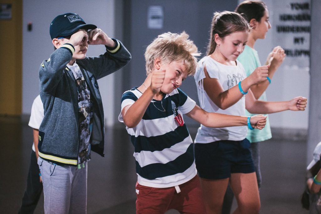 Three children enthusiastically dancing