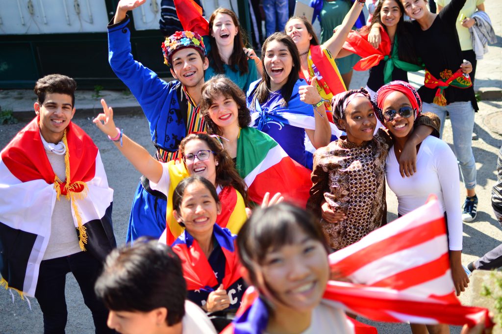 Students wearing national dress and carrying national flags